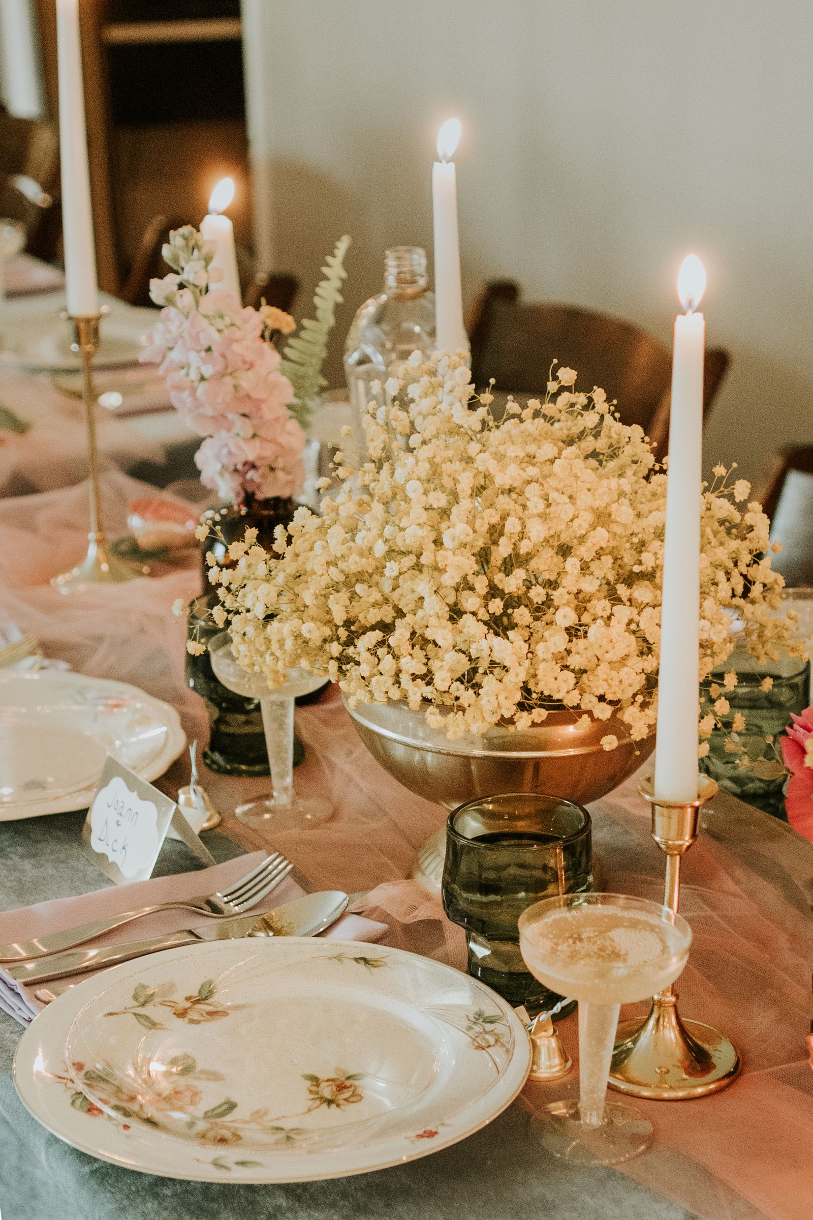 Candlelit wedding table with layered pink and white floral arrangements